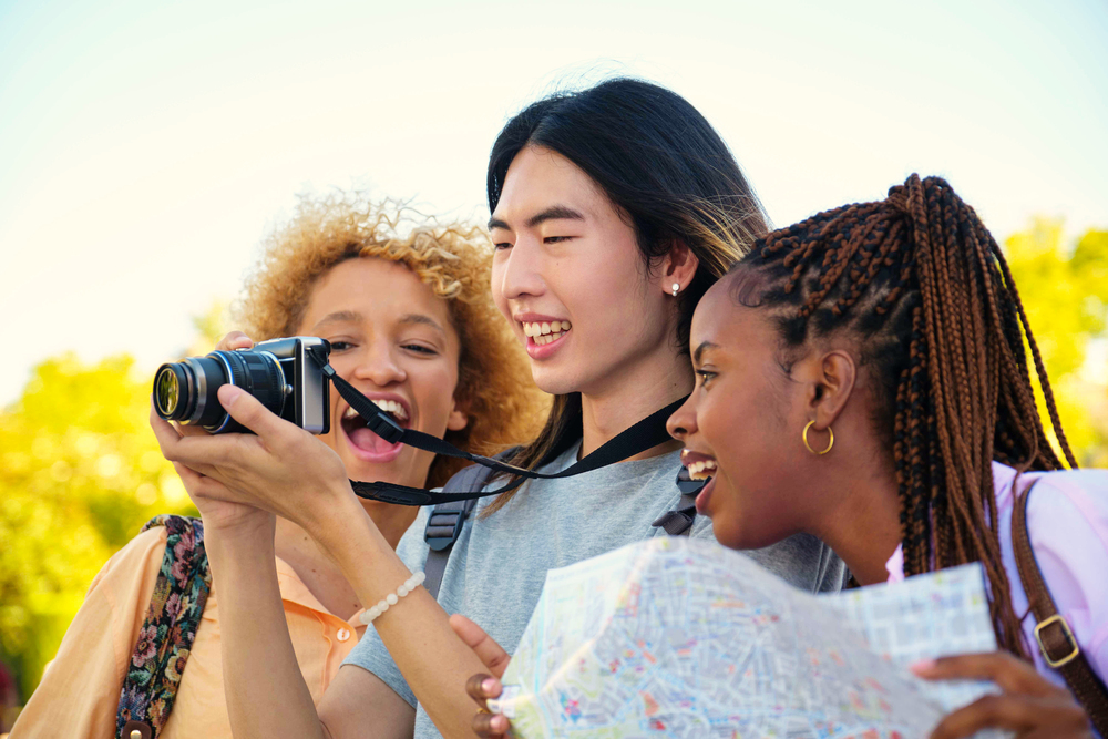 Drie personen kijken naar gemaakte foto op camera